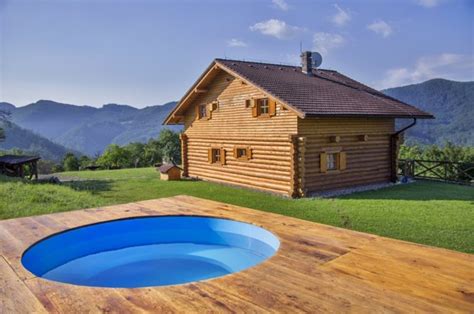 Fotografia záhradnej chaty s terasou a bazénom obklopenej zeleňou