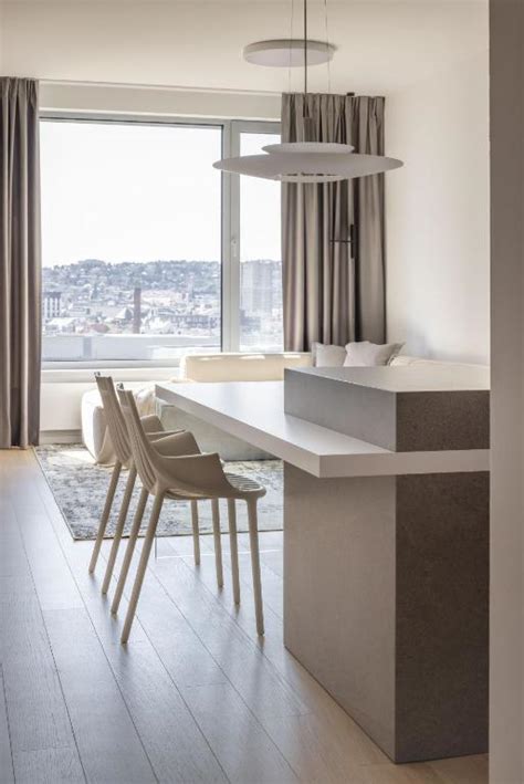 Interiér moderného apartmánu s pracovným stolom a výhľadom na mesto.