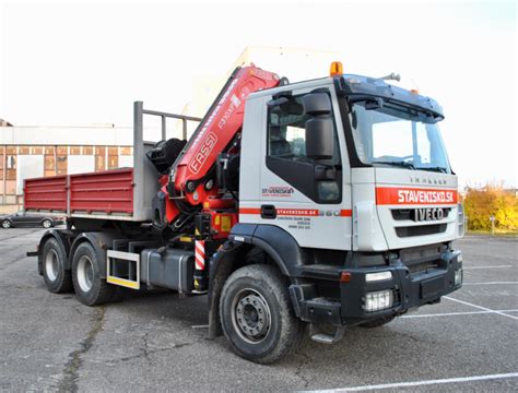 Nákladné auto s hydraulickou rukou nakladá betónové panely