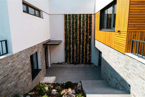 Dizajn fasády parkovacieho domu s drevenými lamelami a popínavými rastlinami