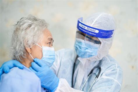 Doctor examining a worker in a protective suit