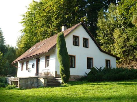 drevená chalupa v lese s dymom z komína