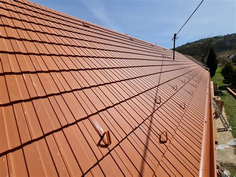 Stará tehlovočervená škridlová strecha s tradičnými hrebenáčmi