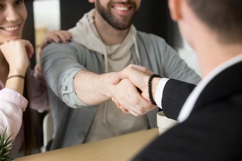 Muž s profesionálnym úsmevom, ktorý podáva ruku klientovi.