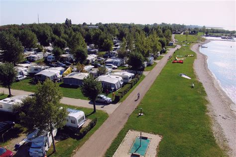 Pohľad na kemp STRANDcamping Podersdorf am See s jazerom v pozadí