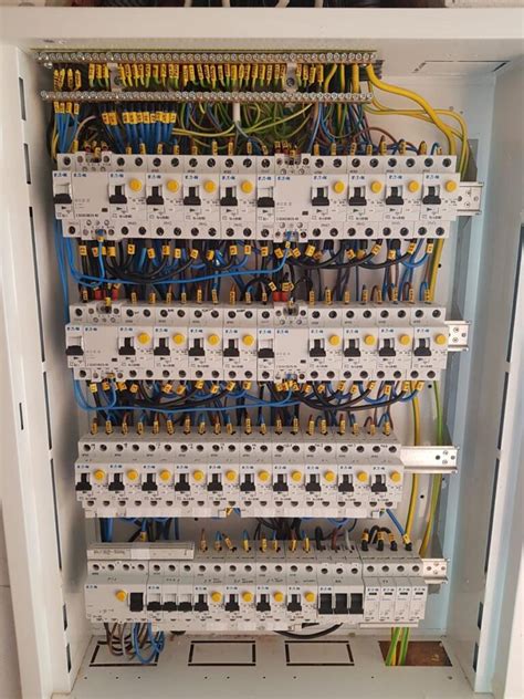 Ilustrácia elektrického rozvádzača s otvorenými dverami, ukazujúca vnútorné komponenty.