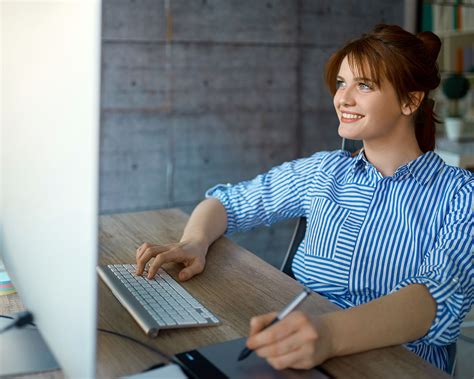 Ilustračná fotografia zobrazujúca osobu pracujúcu na notebooku s úsmevom