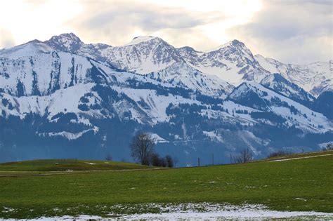 Alpská krajina so zasneženými vrcholmi a zelenými údoliami