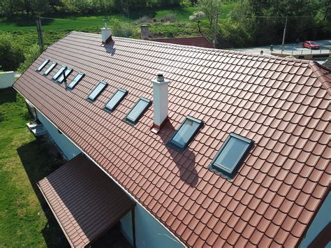 Aplikácia asfaltového tmelu na spoj plechovej strechy