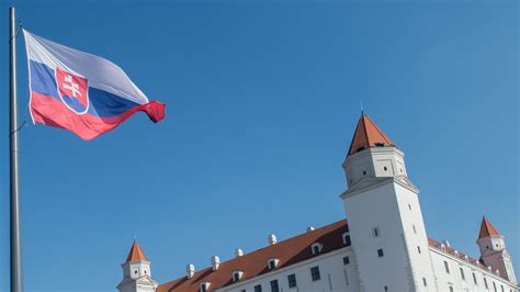 Slovenská vlajka hrdzo vztýčená pred domom na vidieku