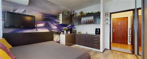 Interiér malej garsónky s posteľou a kuchynským kútom