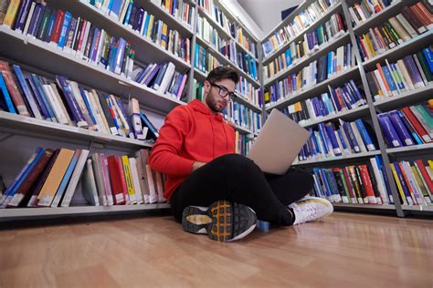 Študent s notebookom a pracovnými dokumentmi