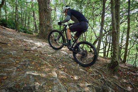 Cyklista nastavuje výšku sedla na bicykli