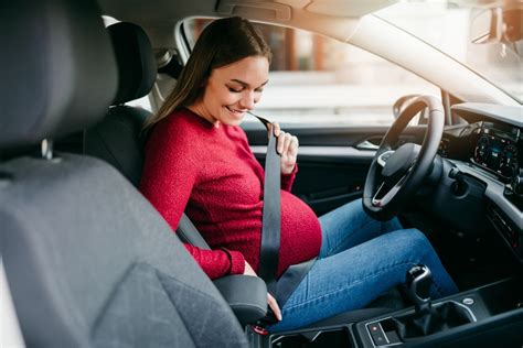 Tehotná žena v aute si zapína bezpečnostný pás