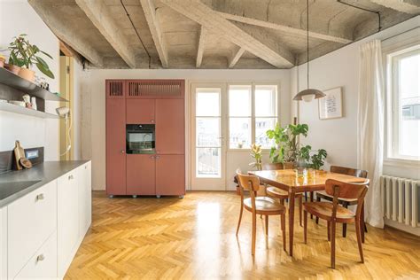 Pohľad na otvorený priestor loftového bytu s betónovým stropom a industriálnymi prvkami