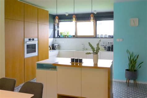 Detail interiéru s betónovým ostrovčekom a dreveným jedálenským stolom