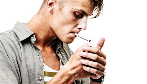 Človek s cigaretou v ruke, obklopený dymom.