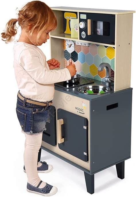 Dieťa hrajúce sa s drevenou detskou kuchynkou