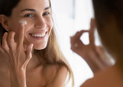 Žena si nanáša krém na tvár