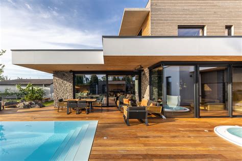 Fotografia rodinného domu s modernou terasou a bazénom.