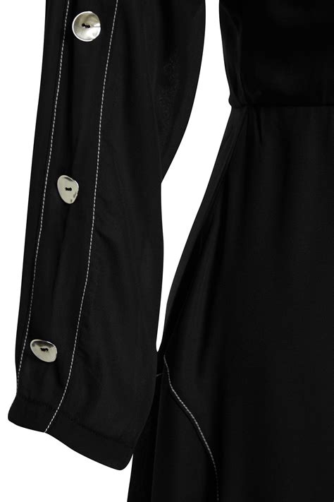 Detail čiernych spoločenských šiat s elegantným doplnkom