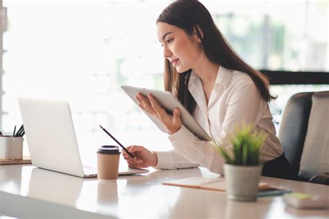 Ilustračná fotografia znázorňujúca človeka pracujúceho s dokumentami a počítačom, symbolizujúca začiatky podnikania.