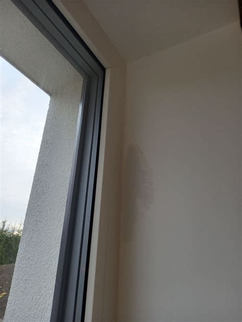 Osoba sediaca pri okne a pozorujúca dážď