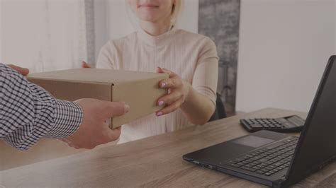 žena zdvíha ťažkú krabicu