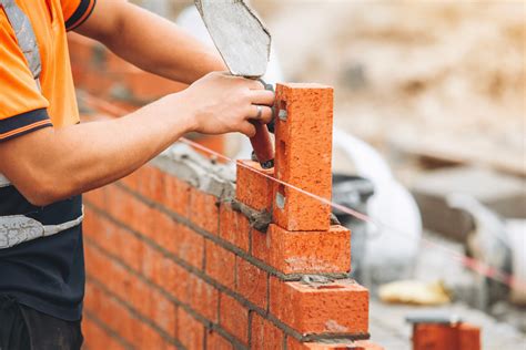 Murár pracujúci s tehlovými blokmi
