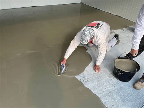 Pracovník aplikuje samonivelačnú hmotu v garáži