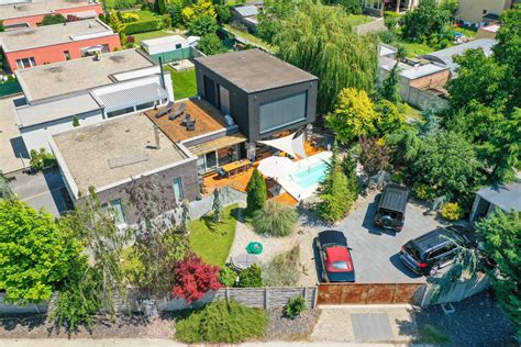 Ilustračná fotografia rodinného domu s dobre udržiavanou záhradou vedľa modernej bytovky