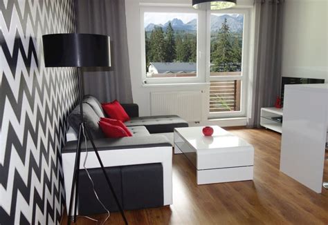 Interiér moderne zariadeného apartmánu s výhľadom na Tatry, zdôrazňujúci česané drevo a vysoké stropy