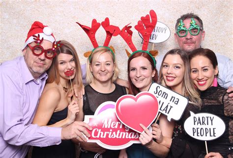 Skupina ľudí sa zabáva pri fotení s vtipnými rekvizitami vo fotobúdke