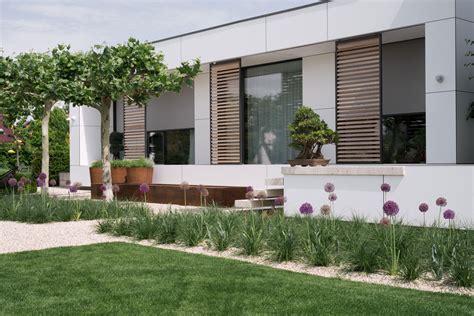 Obraz domu s malou záhradou a kľúčmi v popredí.