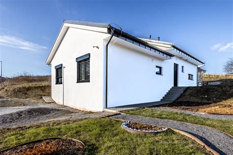 Bočný pohľad na dom s bielou fasádou a pergolou