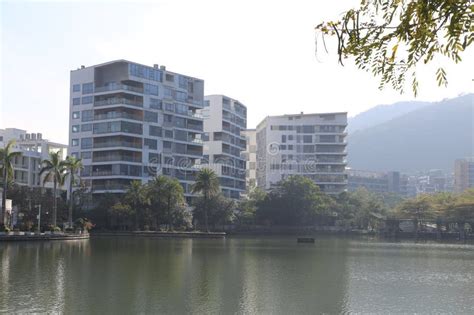 Modern apartment complex by a lake with mountains in the background