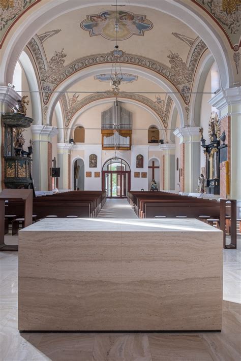 Interiér Kostola sv. Bartolomeja v Hniezdnom s novou kamennou podlahou a moderným travertínovým oltárnym stolom.