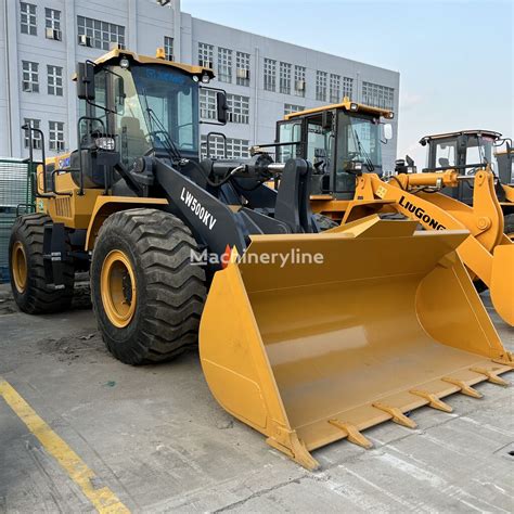 Kolesový nakladač nakladajúci materiál na nákladné vozidlo