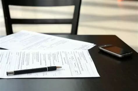 Osoba pri čítaní dokumentov na stole s historickým artefaktom v pozadí