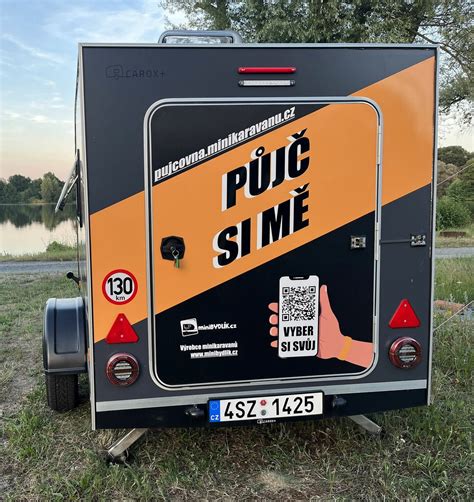 minikaravan pripojený k autu na cestnej komunikácii