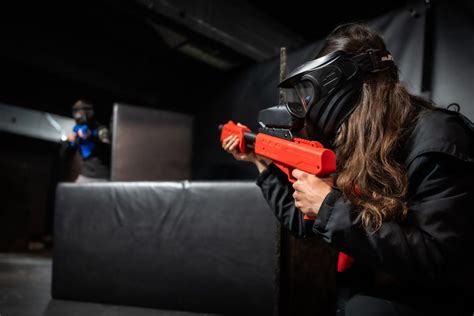 Hráči paintballu s maskami a zbraňami