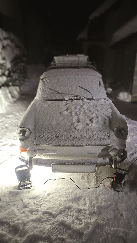 Dielňa s rozloženým veteránom a mechanikmi pracujúcimi na rôznych častiach