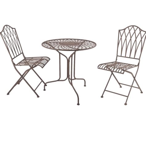 Starý, hrdzavý kovový stôl a stoličky v záhrade