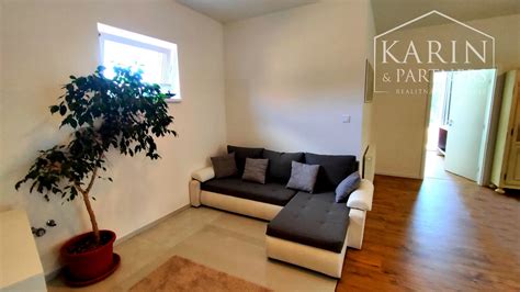 Ilustračná fotografia symbolizujúca prenájom nehnuteľnosti, napr. kľúč od bytu na kope mincí